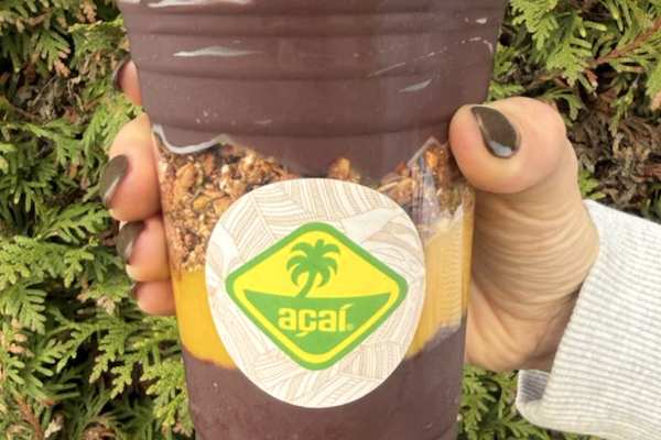Acai cup vastgehouden in een hand, met Acai softserve uit een Acai machine of Acai softijsmachine